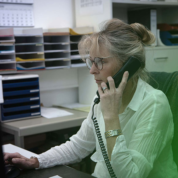 Mitarbeiterin im Büro am Telefon