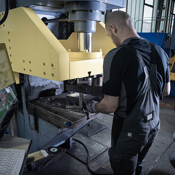 Mitarbeiter beim Arbeiten an der Hydraulikpresse
