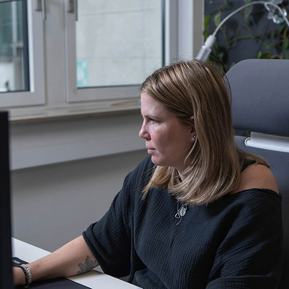 Mitarbeiterin im Büro schaut auf ihren Monitor