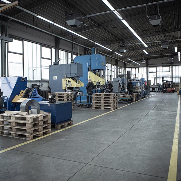 Blick in die Fertigungshalle. Zu sehen sind Maschinen und Material
